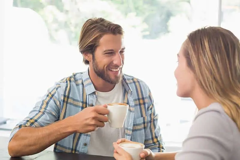 happy couple talks while drinking coffee