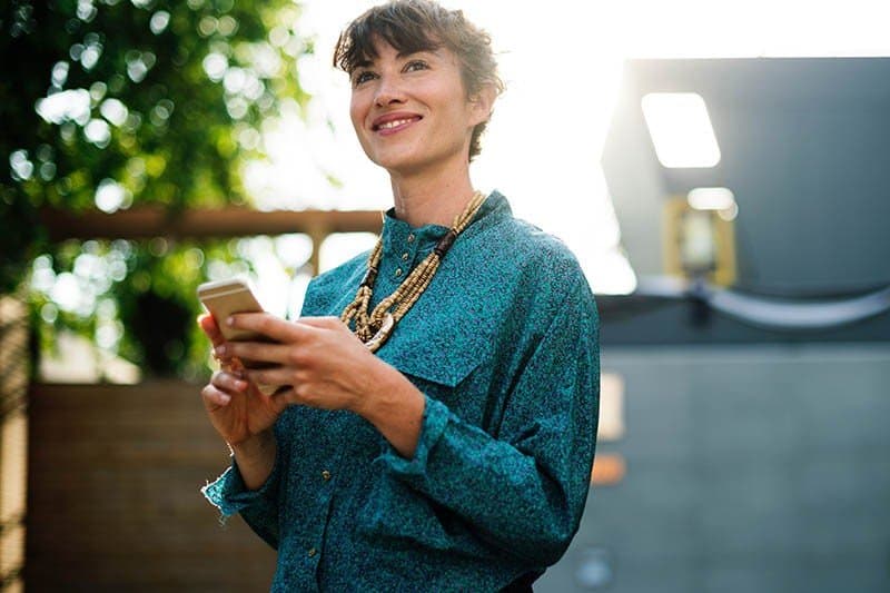 mujer feliz sosteniendo un teléfono móvil 