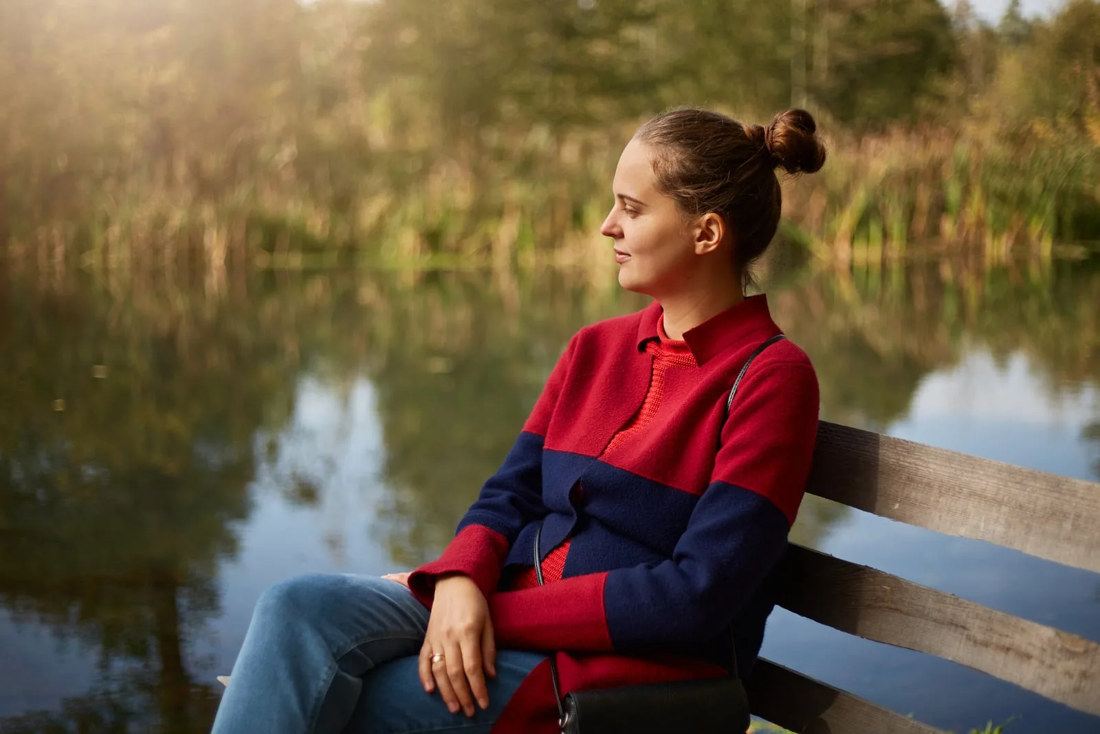 pensive woman sitting on wooden bench