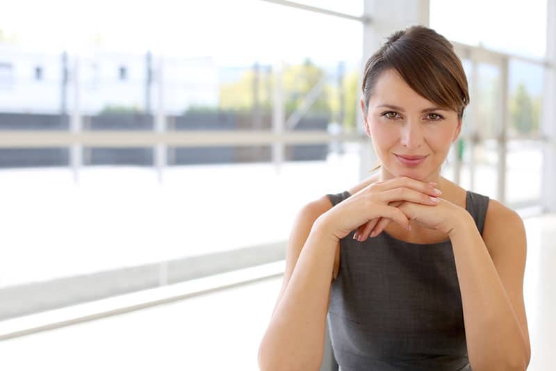 ritratto di donna sorridente che si appoggia sulle mani