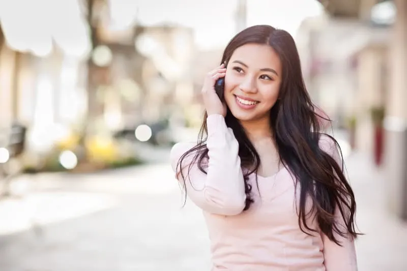shallow focus of smiling woman talking on her phone