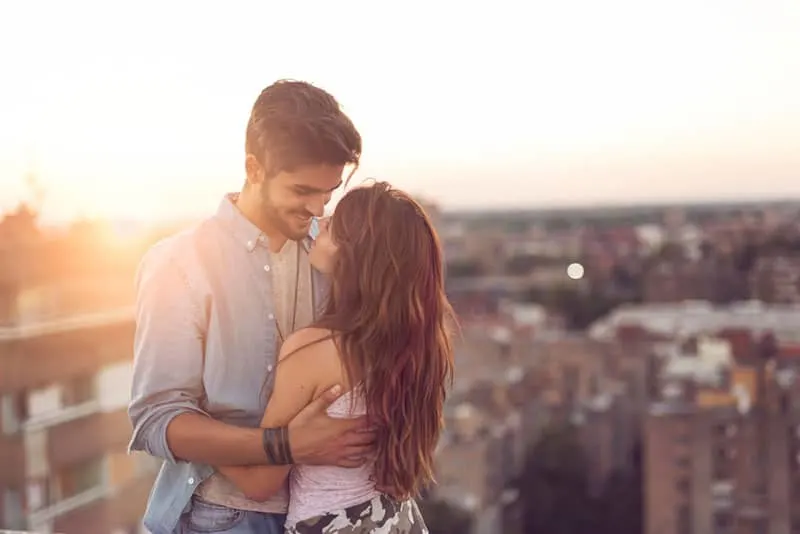 Couple in love standing and hugging on a building rooftop 