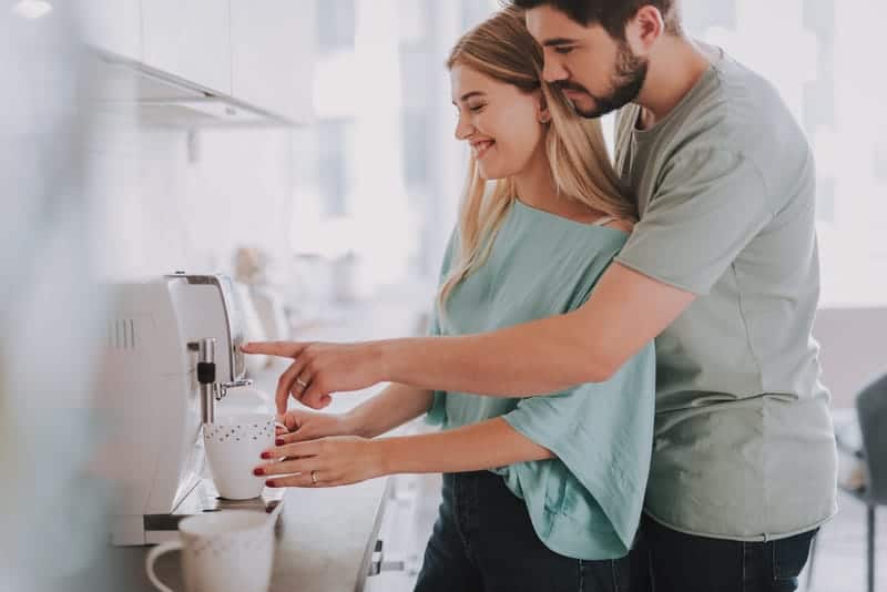 mujer y hombre felices haciendo café 