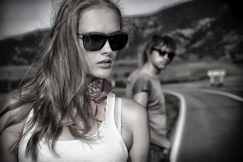 Couple of modern young people posing on a road