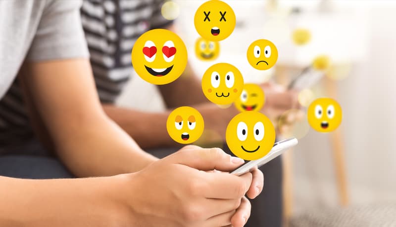  Teen guy using smartphone sending emojis