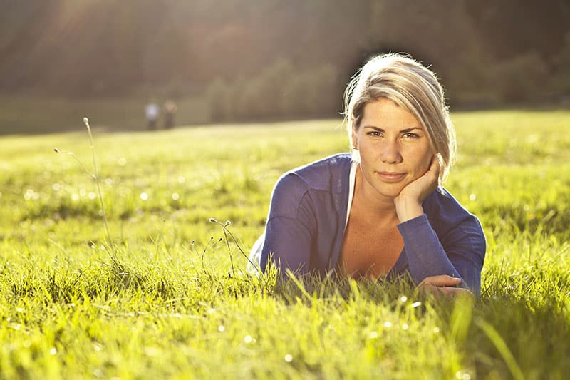 Retrato de uma mulher loira a descontrair no parque