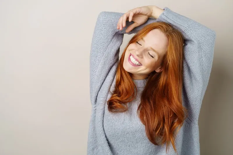 Happy carefree young redhead woman with a cute grin