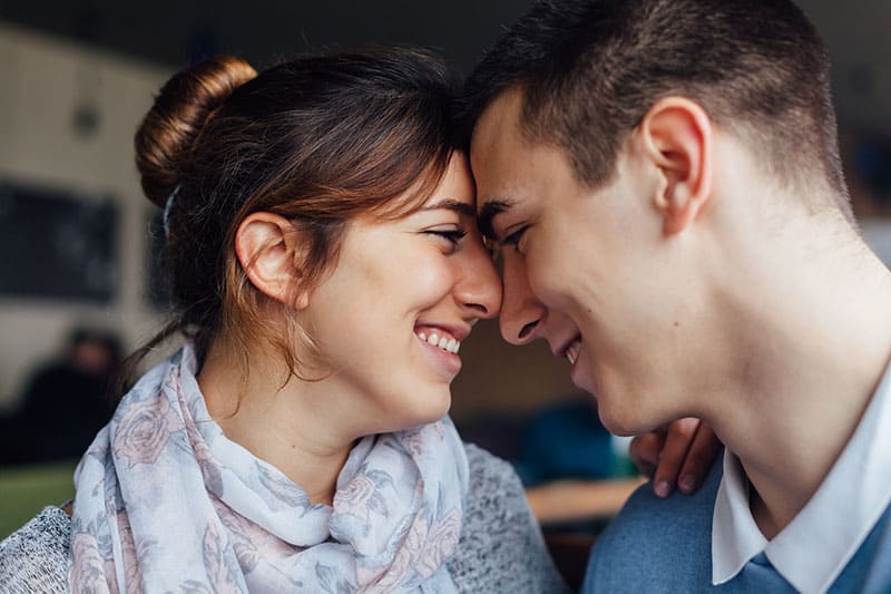 smiling man and woman face to face each other