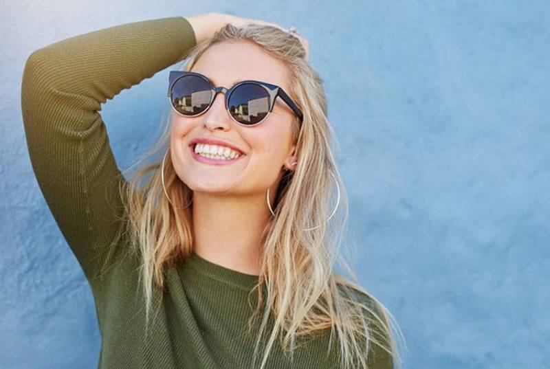 donna sorridente con occhiali da sole