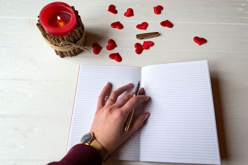 woman hand on notebook holding pen