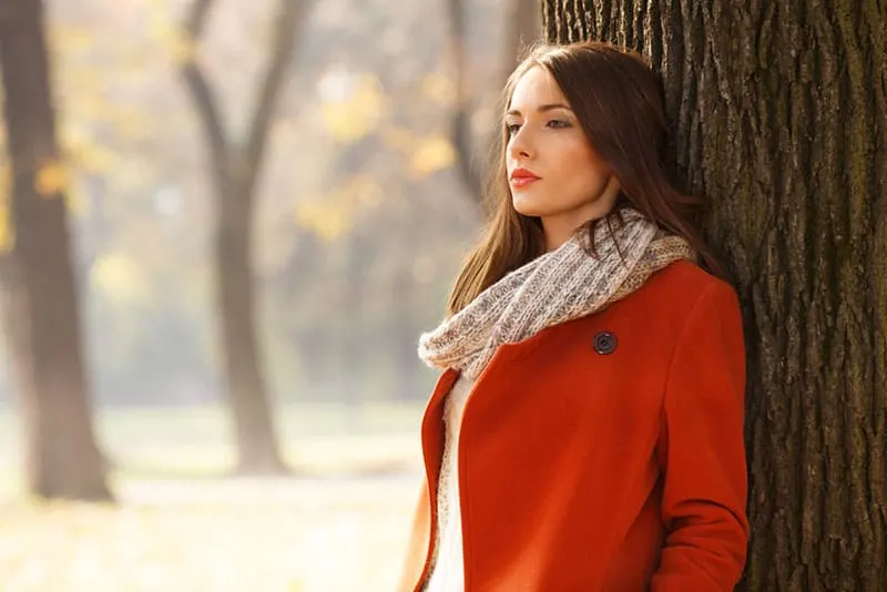 worried woman wearing red coat standing outdoor