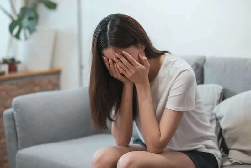 young woman crying on the couch