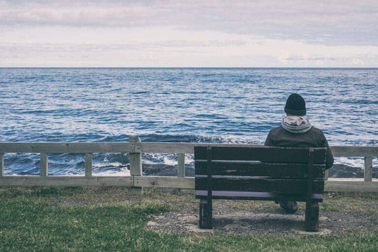 man sitting alone in front of sea