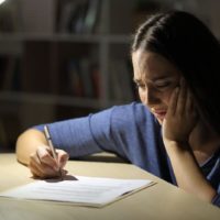 donna in lacrime che scrive una lettera