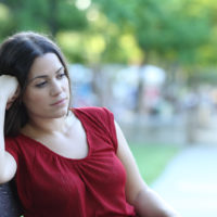 woman sitting on a bench in a park looking away