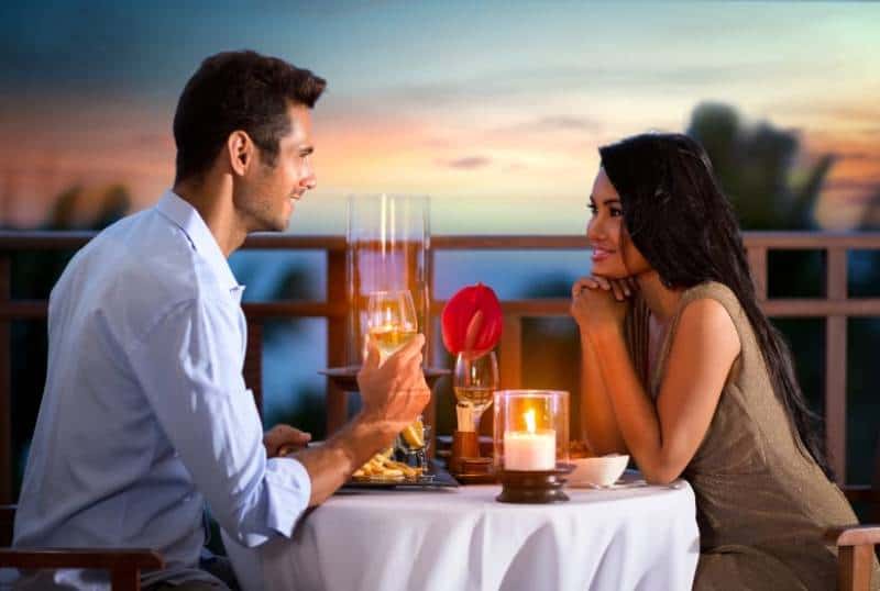 Pareja feliz en una noche de verano teniendo una cena romántica