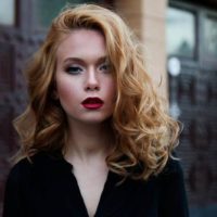 blonde woman looks serious outside on street