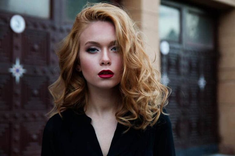 blonde woman looks serious outside on street