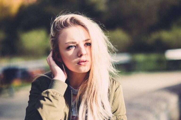 young blonde woman looks thouhgtful