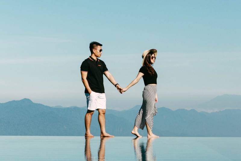 Uomo e donna si tengono per mano all'esterno