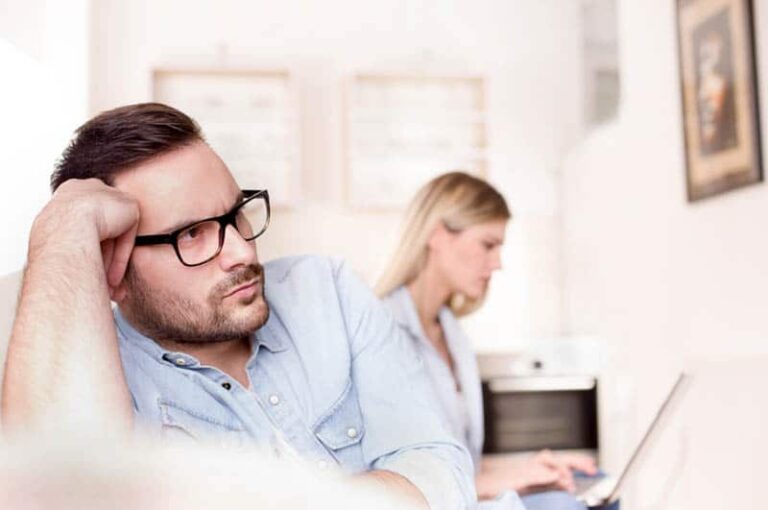 thoughtful man sitting next to woman at home