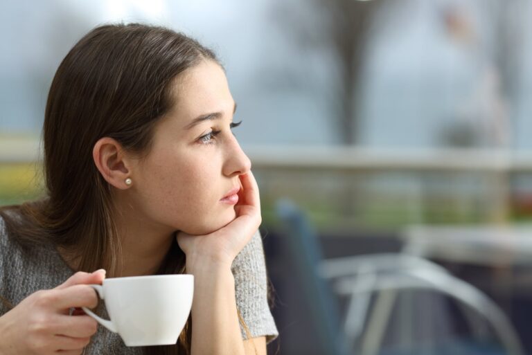 Pensive woman holding a coffee cup