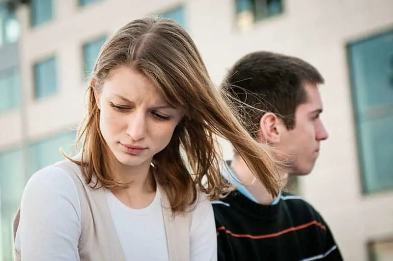 Portrait of young woman and man outdoor on street having relationship problems