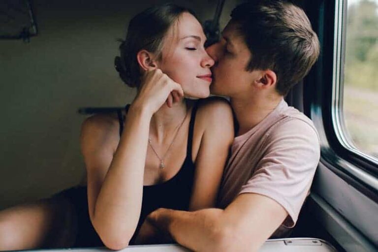 man kisses woman in the public transport