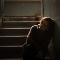 mujer triste sentada en las escaleras