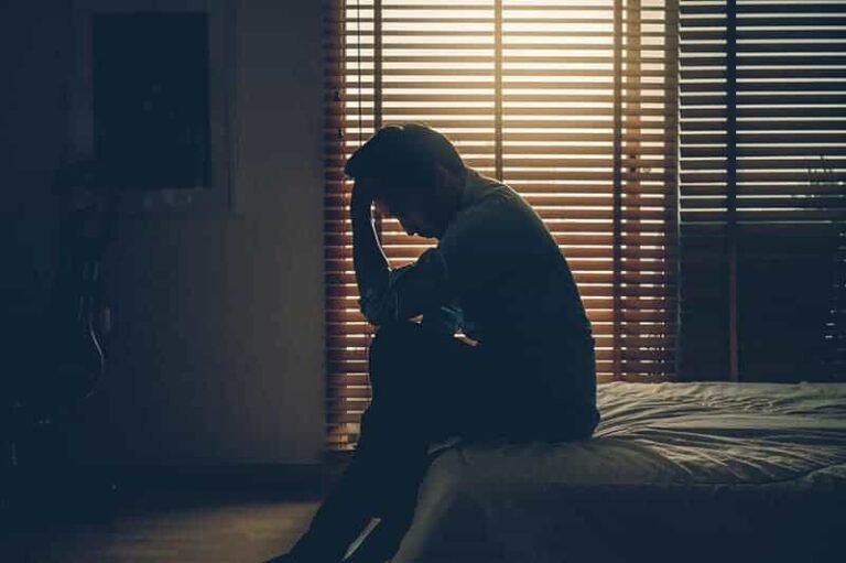 depressed man sitting on bed