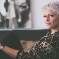 woman with short hair sitting on couch at home