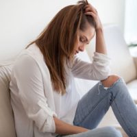 sad woman sitting on sofa