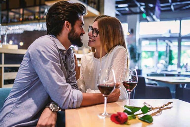 smiling couple sitting close to each other at restaurant
