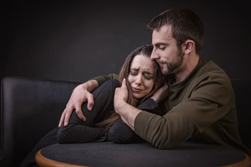 Joven consolando a su novia