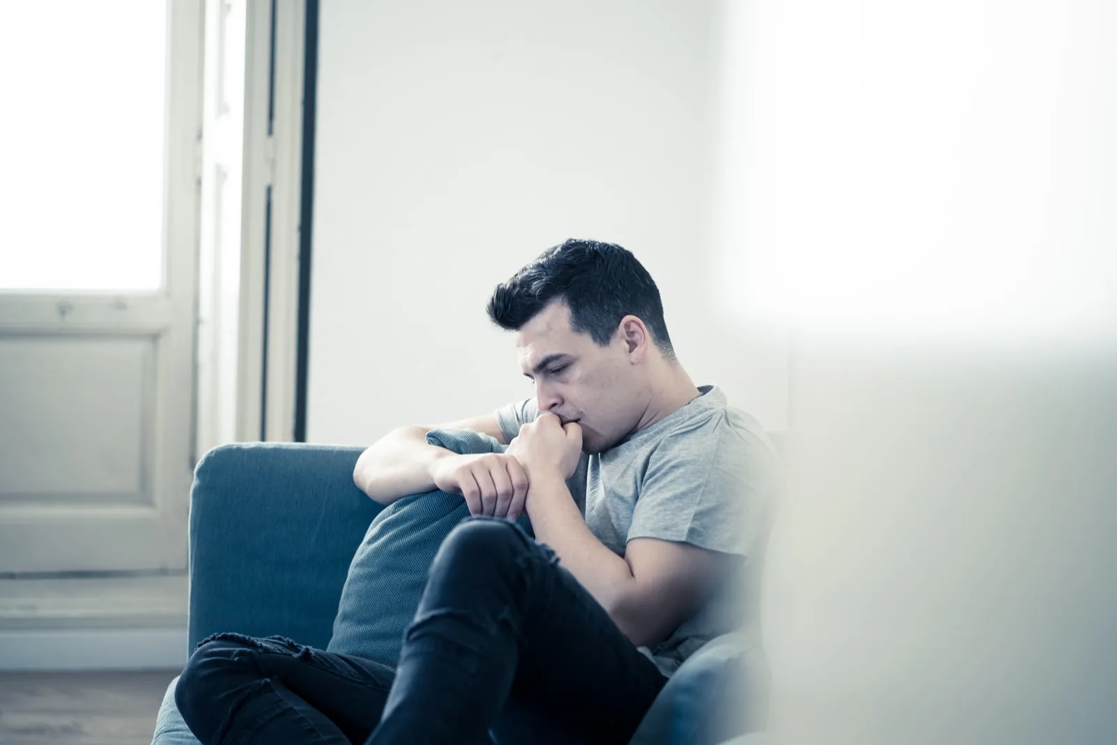 a depressed man sitting on the couch