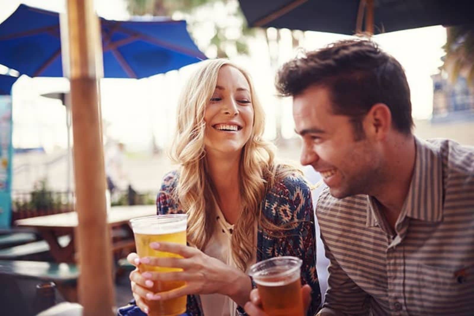 a man and a woman drinking beer and laughing