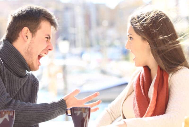 angry couple outside at cafe