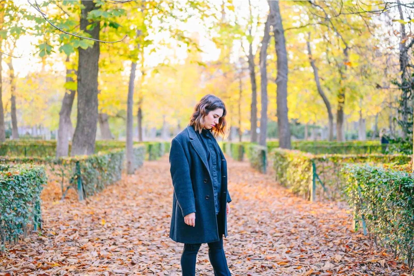 autumn in the park stands a sad woman
