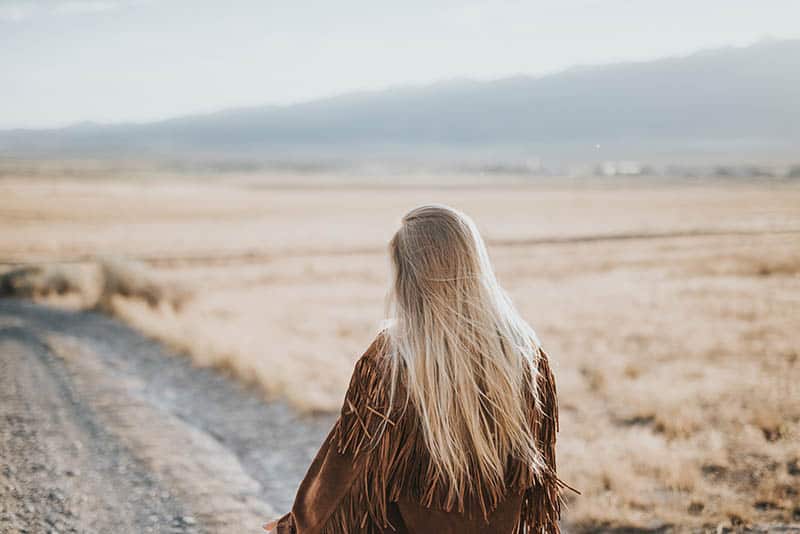 back view of woman walking on field