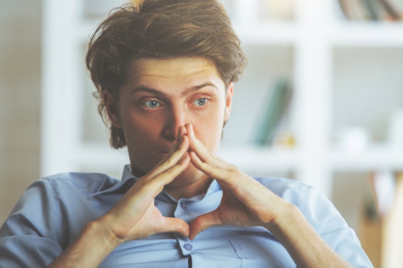 close up photo of thoughtful man wearing blue shirt