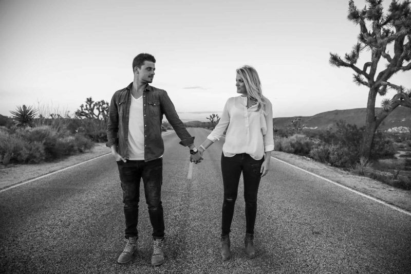 couple holding hands on road