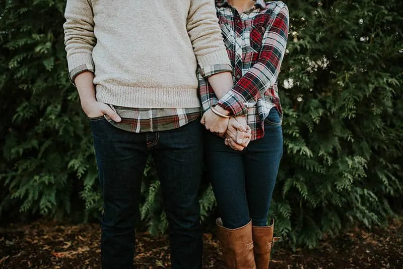 couple holds their hands outside