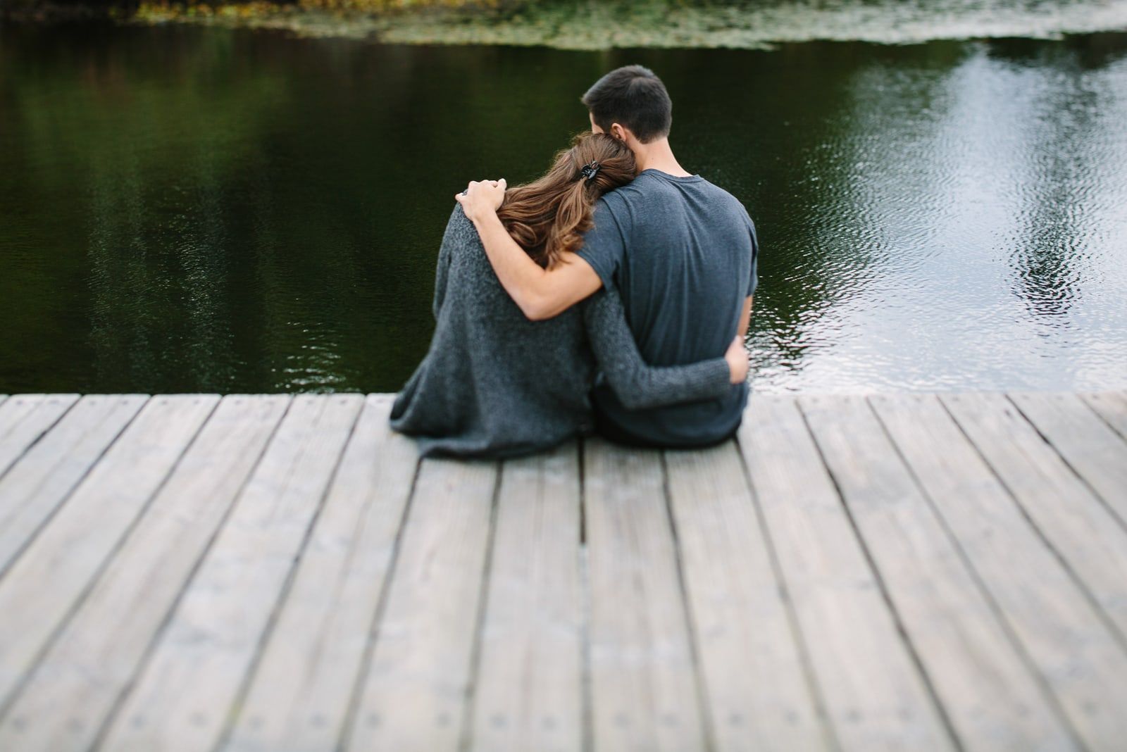 coppia seduta in riva al lago