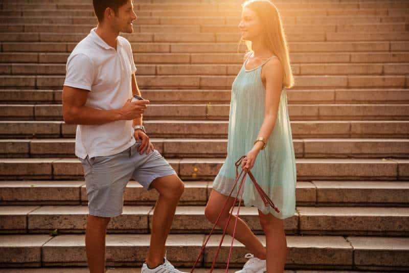 pareja hablando fuera en las escaleras puesta de sol