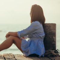 woman sitting alone near the sea