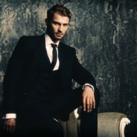 Portrait of a handsome man in an elegant suit on a grunge background. Studio shot.