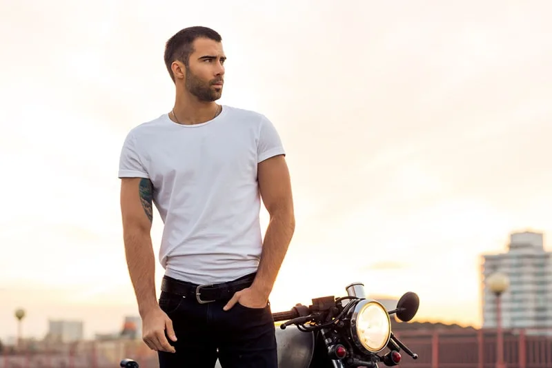 handsome man standing with motorbike