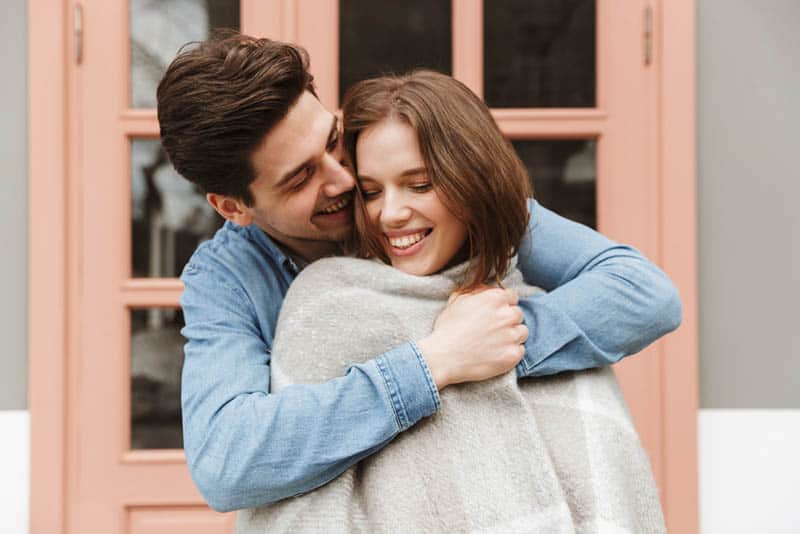 happy beautiful couple hugging outside