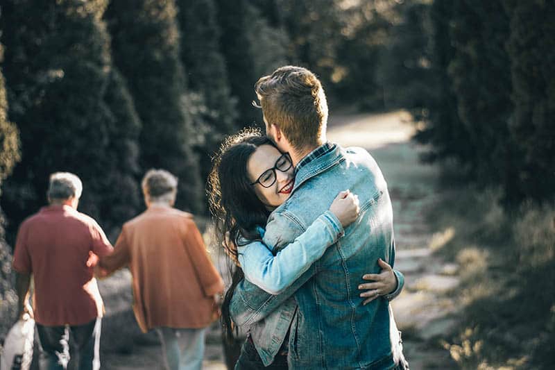 mujer feliz abrazando a un hombre al aire libre