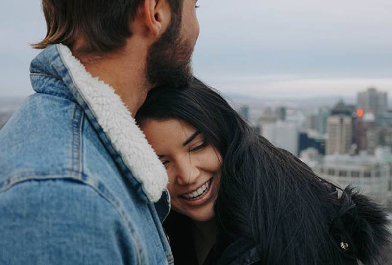 homem a abraçar mulher sorridente